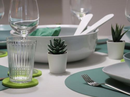 a table with a wine glass and plants on it at Apartment Allod Park Haus C 202 by Interhome in Davos