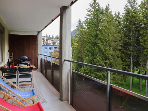 a balcony with chairs and a table and trees at Apartment Allod Park Haus C 202 by Interhome in Davos