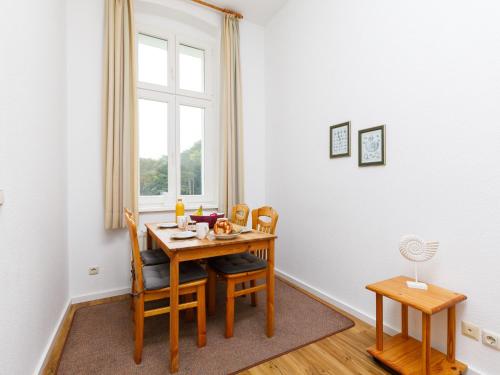 ein Esszimmer mit einem Tisch, Stühlen und einem Fenster in der Unterkunft Apartment Zinnowitzer Hof-5 by Interhome in Zinnowitz