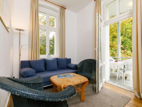 uma sala de estar com um sofá azul e cadeiras em Apartment Zinnowitzer Hof-5 by Interhome em Zinnowitz