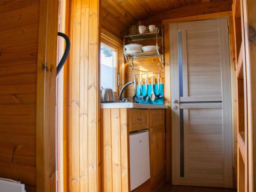 eine kleine Küche mit einem Waschbecken und einer Tür in der Unterkunft Holiday Home Kemp Stříbrný rybník-1 by Interhome in Hradec Králové