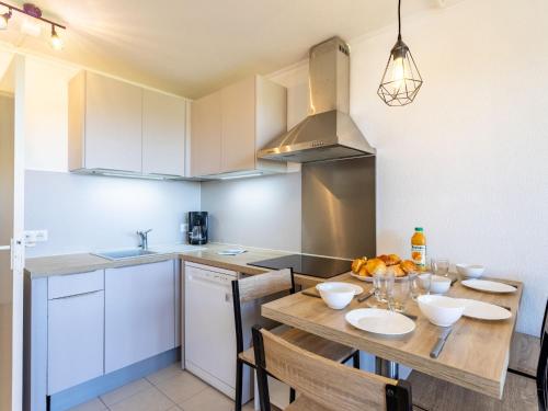 uma cozinha com uma mesa de madeira e uma sala de jantar em Apartment Les Marines-43 by Interhome em Gassin