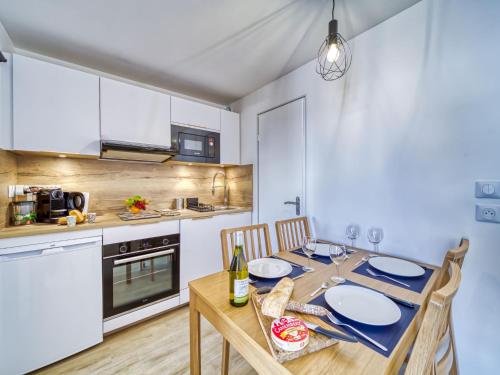 une cuisine avec une table en bois et des chaises ainsi qu'une salle à manger dans l'établissement Apartment Altineige-6 by Interhome, à Val Thorens