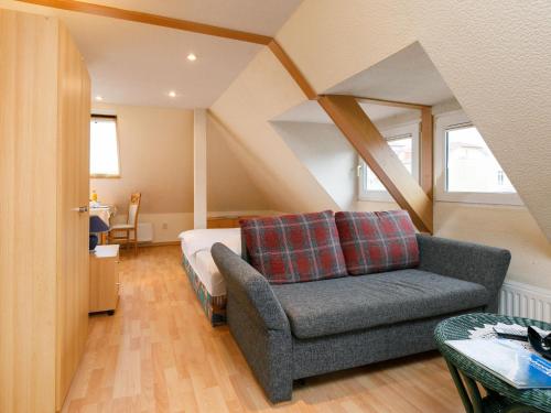 Un dormitorio con una cama, un sofá y una silla. en Apartment Melchien 2 by Interhome, en Zinnowitz