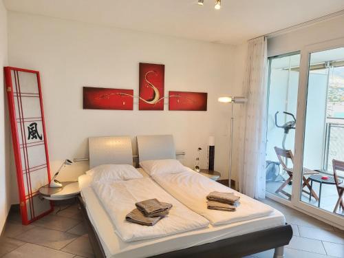 a bedroom with a bed with two towels on it at Apartment Torre Tessuti Apt-Stefano by Interhome in Locarno