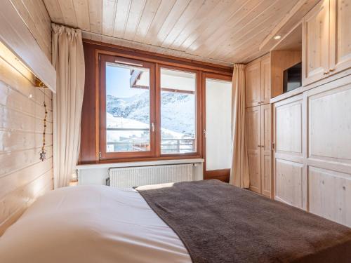 une chambre avec un lit et une grande fenêtre dans l'établissement Apartment Le Curling B - Val Claret-41 by Interhome, à Tignes