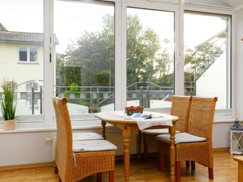 Un comedor con mesa y sillas y ventanas. en Apartment Luise von Preußen - App- 205 by Interhome, en Zinnowitz