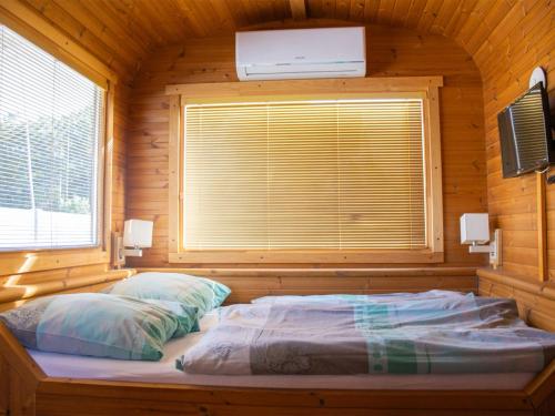 a bed in a wooden room with a window at Holiday Home Kemp Stříbrný rybník-7 by Interhome in Hradec Králové