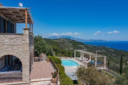 a villa with a swimming pool and a view of the ocean at Villa Armos in Skinária