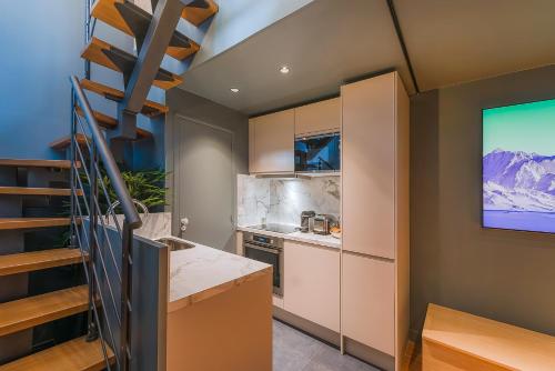 una cocina con una escalera que conduce a una sala de estar. en Séjour au Taj proche Tour-Eiffel, en París