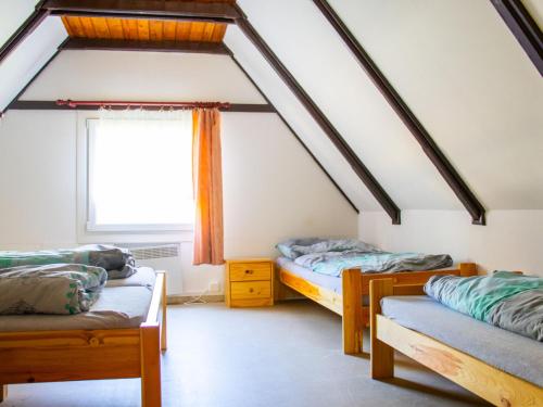 フラデツ・クラーロヴェーにあるHoliday Home Kemp Stříbrný rybník-15 by Interhomeのベッド2台と窓が備わる屋根裏部屋です。