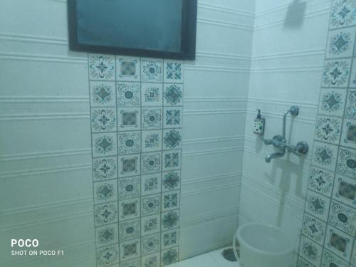 a bathroom with a toilet and a tv on the wall at Sohan guest house in Chandīgarh