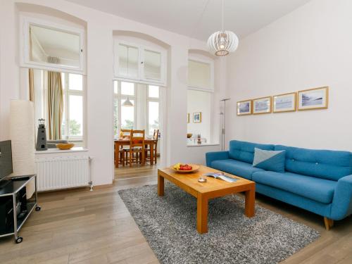 een woonkamer met een blauwe bank en een tafel bij Apartment App-6 Zinnowitzer Hof by Interhome in Zinnowitz