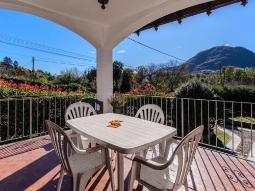 a white table and chairs on a deck with flowers at Apartment Roberto by Interhome in Mergozzo