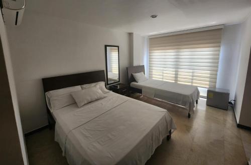 a bedroom with two beds and a window at Hotel Ciudad Capri in Cali