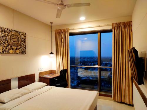 1 dormitorio con cama, escritorio y ventana grande en Ginger Chennai, en Chennai