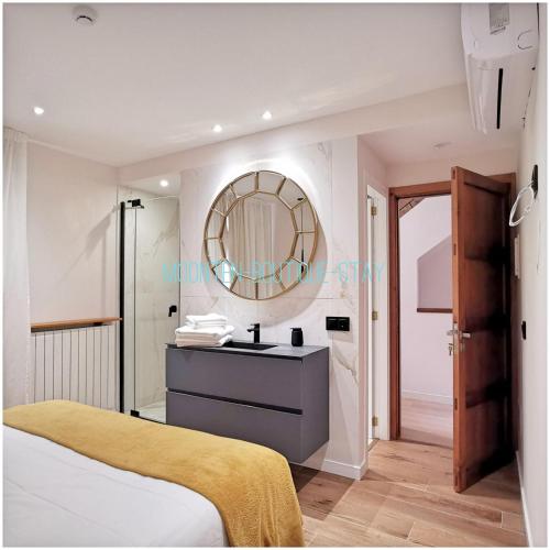 a bedroom with a sink and a mirror at MOONTEN Boutique Stay in Sóller