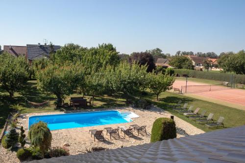 a swimming pool in a yard with a tennis court at U Fousáče in Hrabětice