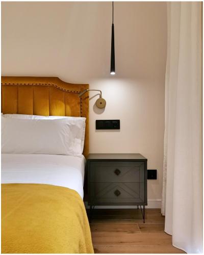 um quarto com uma cama e um candeeiro numa mesa de cabeceira em MOONTEN Boutique Stay em Sóller