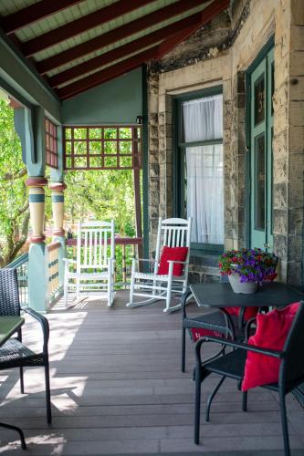 a porch of a house with chairs and a table at Stone Gables Inn in Cleveland