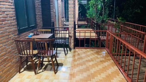 a patio with a table and chairs on a balcony at Gibbon Singing Home Stay in Quan Tom