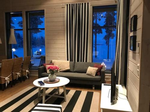 een woonkamer met een bank en een tafel bij Villa Vilmala in Sääskilahti