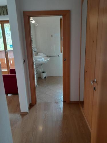 a hallway with a bathroom with a sink and a mirror at Landgasthof Sonnegghof in Castelvecchio