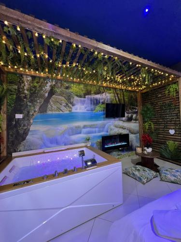 a bath tub in a room with a waterfall mural at The Flower Garden in Castellammare di Stabia