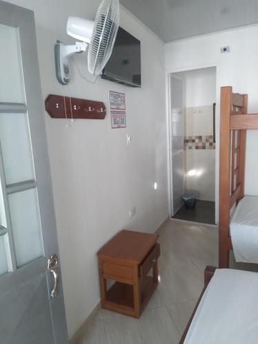 Habitación pequeña con ventilador y mesa. en Hotel Zarina en Villavicencio