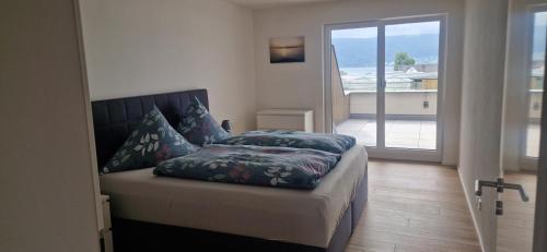 a bedroom with a bed and a sliding glass door at Ferienwohnungen Christian Keller in Reichenau