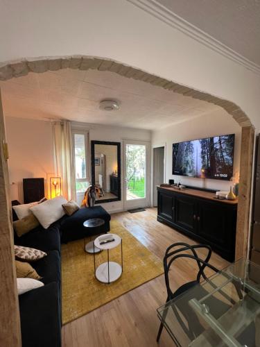 un salon avec un canapé et une télévision dans l'établissement Charmante Maison centre deauville, à Deauville