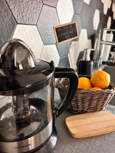 a tea kettle on a counter with a basket of oranges at Bon Bon del Centro no Ztl a due passi da Piazza Alfieri in Asti