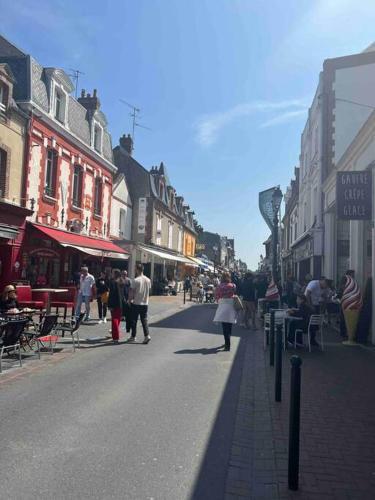 a group of people walking down a city street at Appartement élégant et chaleureux in Cabourg
