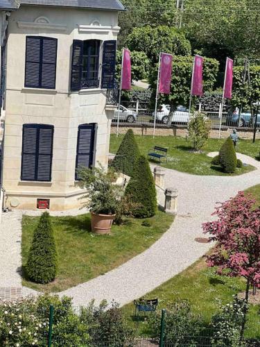a house with pink flags in front of it at Appartement élégant et chaleureux in Cabourg