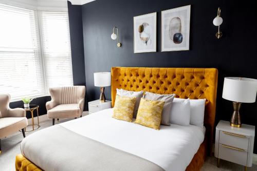 um quarto com uma grande cama branca com almofadas amarelas em The Salisbury - Luxury Apartments by Stay In Scarborough em Scarborough