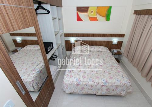1 dormitorio con 2 camas y espejo en L'acqua diRoma com Super Ofertas, en Caldas Novas