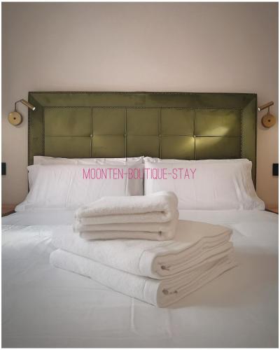 a bed with towels on it with a sign on it at MOONTEN Boutique Stay in Sóller