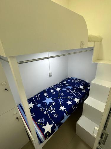 a bunk bed with a blue blanket with stars on it at Deluxe Loft Rooms near Burjuman Metro Station , Bur Dubai in Dubai