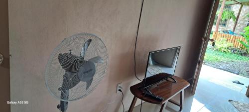 een kamer met een ventilator en een bureau met een laptop bij Bijagua paradise Río Celeste in Bijagua