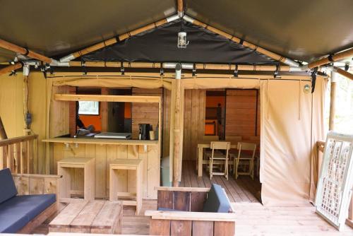 um interior de uma tenda com uma mesa e cadeiras em Camping Pittoresque em Saint-Parthem