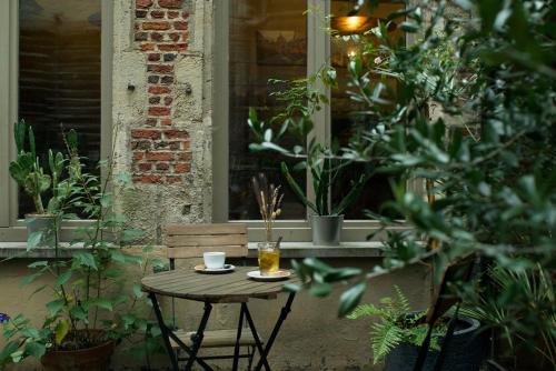 una pequeña mesa con una taza de café y una bebida en Hotel Matelote en Amberes
