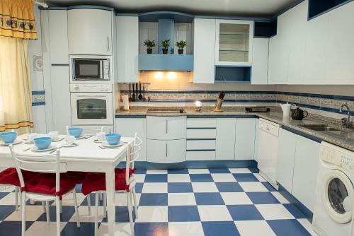 a kitchen with blue cabinets and a checkered floor at CASA DOVELA in Jarandilla de la Vera