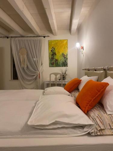 a bed with orange and white pillows on it at EDERA dei Guatto in Bertiolo