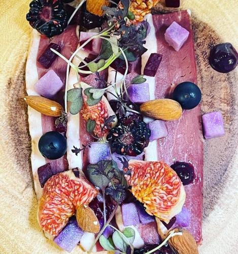 a pizza with fruit and vegetables on a plate at Logis des Sittelles in Montfort-le-Gesnois