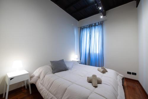 1 dormitorio con 1 cama blanca grande y ventana en La Casa del Palio, en Ronciglione