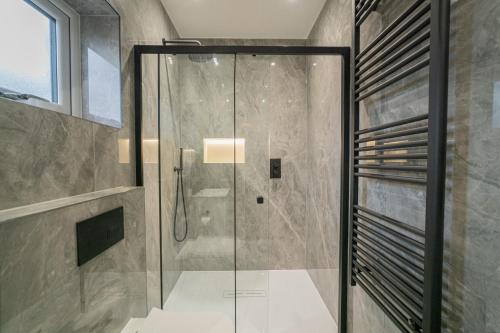 a shower with a glass door in a bathroom at One & Two Bedroom Apartments near Holloway Train Station by Belvilla in London