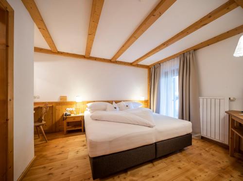 a bedroom with a large bed in a room at Hotel Tann in Collalbo