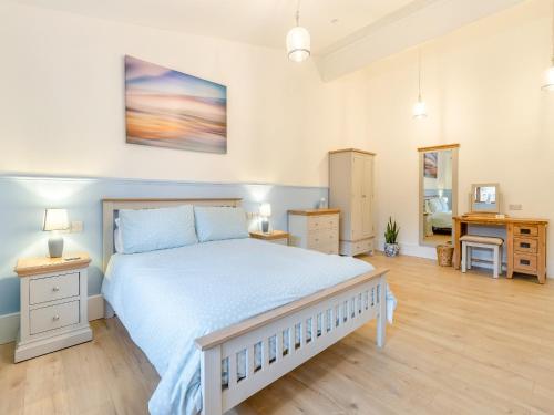 a bedroom with a large white bed with blue sheets at Lime Lodge - Uk42547 in Llanwrthwl