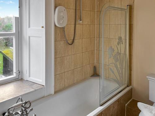een douche met een glazen deur in de badkamer bij One Springfield in Tain