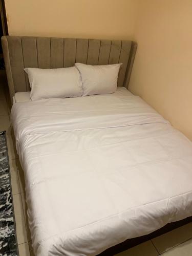 a bed with white sheets and pillows at Badr pyramids inn in Cairo